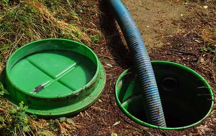 residential septic tank open with hose in it