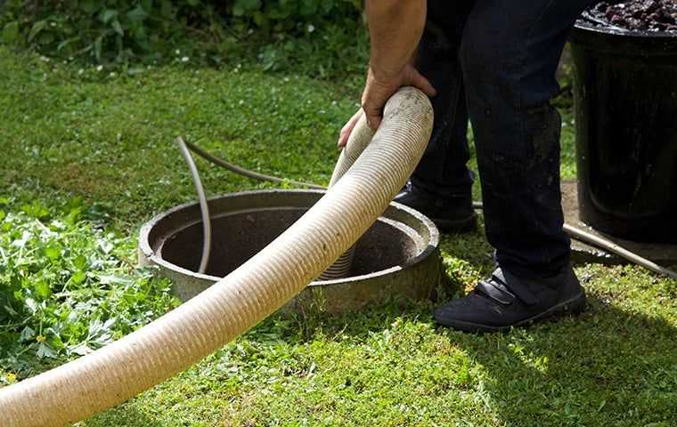 technician cleaning a septic tank